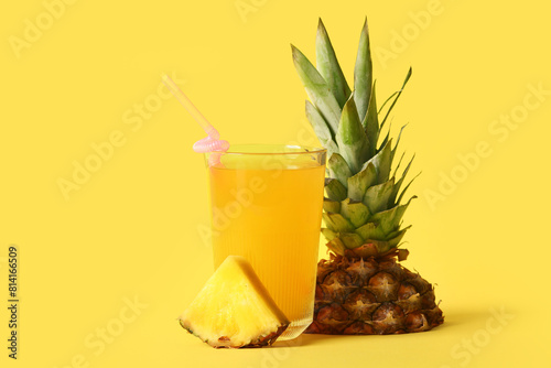 Glass of fresh tasty pineapple juice on yellow background