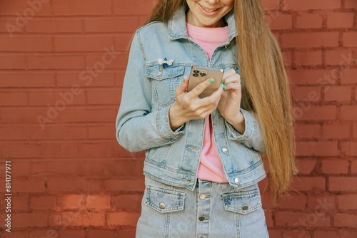 Smiling cheerful amazed woman using device gadget app smm post over bright brick wall background