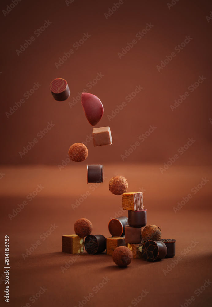 flying chocolate candies on brown background flying chocolate candies on brown background