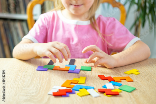little 5 year old girl playing at home with wooden blocks, child's hand explore intricate world colorful wooden puzzle, nurturing creativity, imagination and problem-solving skills