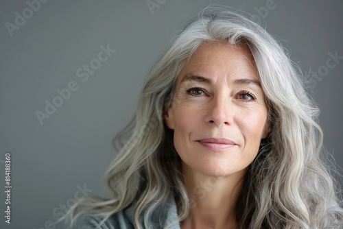 An older woman with gray hair gazes directly at the camera.