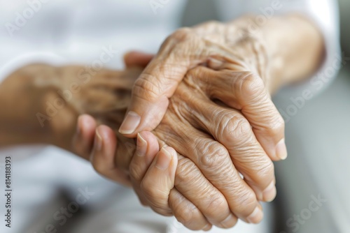 An elderly womans hands are intertwined, showing signs of aging and fragility.