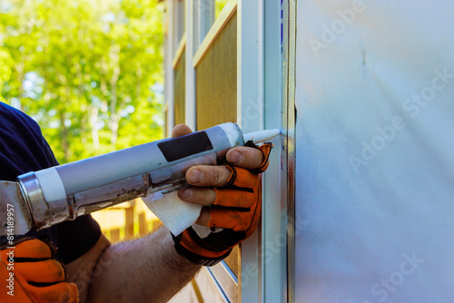 After windows have been installed, seams are coated with silicone, seals are stripped photo