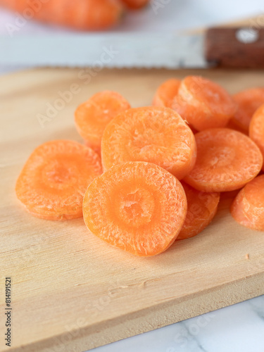 Chopped carrots on wooden cutting board. Close-up. Preparation of organic root vegetable for salad.