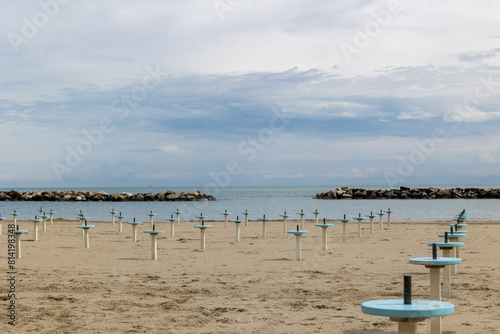 Romagna or Riviera Romagnola beach, off season mood. Before season starts in april or may, or october. Liminal spaces, slight melancholy feeling, uncertain weather, damp sand.
