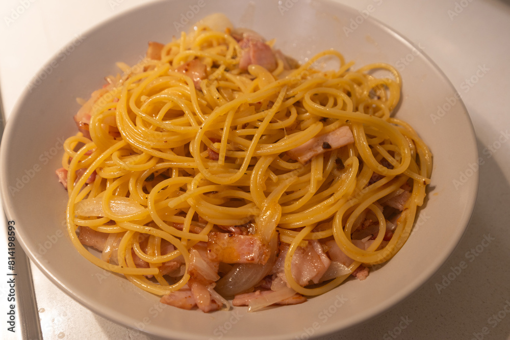 Spaghetti carbonara with bacon and onion.