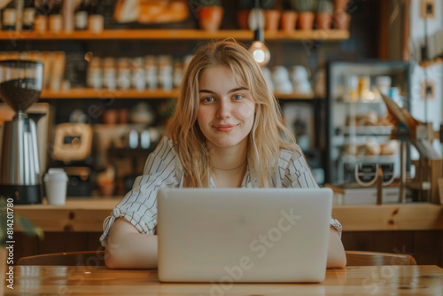 Young woman working on a laptop while sitting in coffeeshop