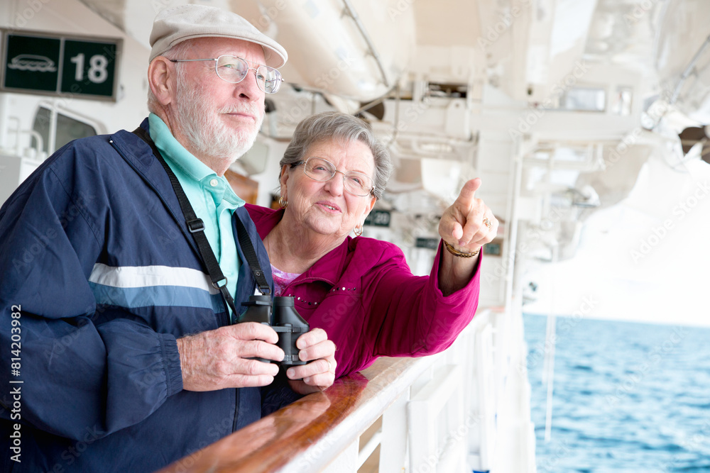 Obraz premium Senior Adult Couple Enjoying The View From Their Passenger Cruise Ship with Their Bonoculars.