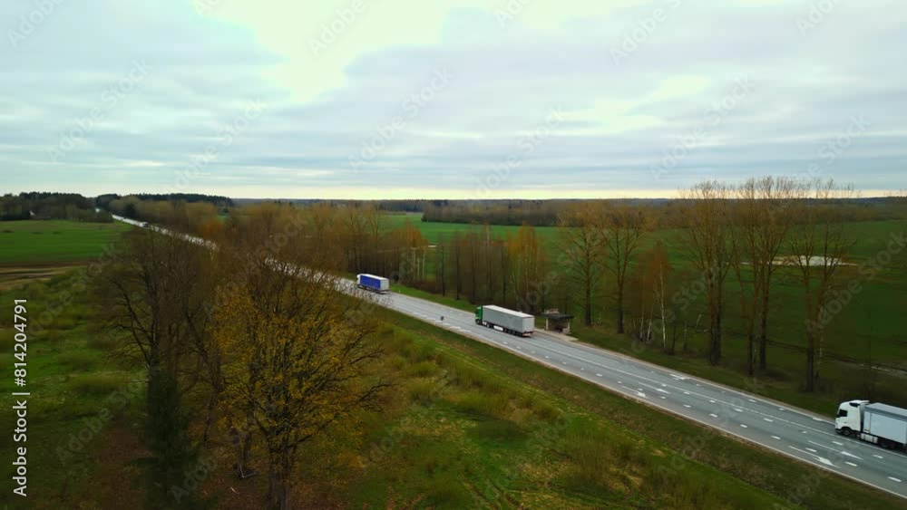 A vehicle on asphalt road crossing grasslands under cloudy sky A vehicle on asphalt road crossing grasslands under cloudy sky