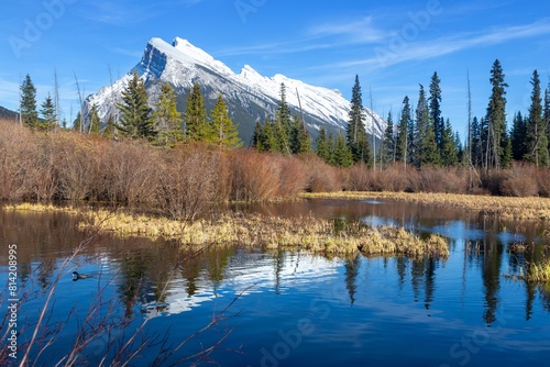 Snowy Rundle Mountain Peak Reflected in Vermilion Lakes Calm Water.  Scenic Banff National Park Landscape View. Canadian Rockies Springtime Hiking photo