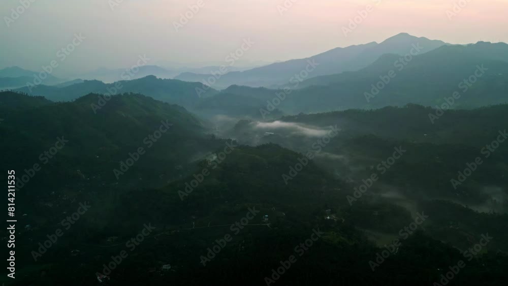 Drone sunrise over misty Ella mountain ranges in Sri Lanka. Revealing valleys, peaks. Nature lovers, tourists explore early morning. Breathtaking landscape for travel seeking tranquility, beauty.