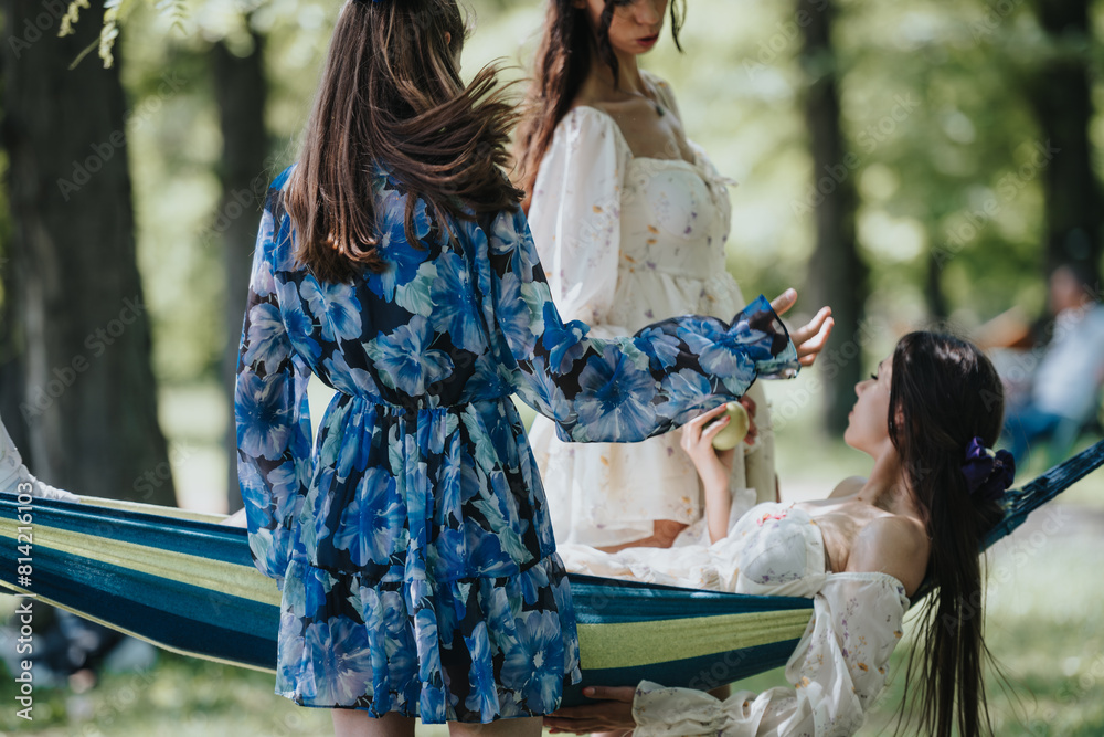 Naklejka premium Two sisters spend quality time in a park, one reclining in a hammock while chatting with the other, highlighting a bond in a serene setting.