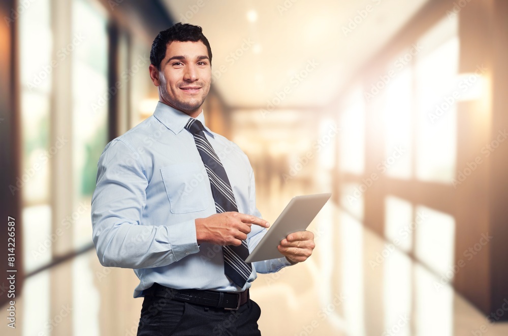 Happy young business man holding tablet computer at work. Happy young business man holding tablet computer at work.