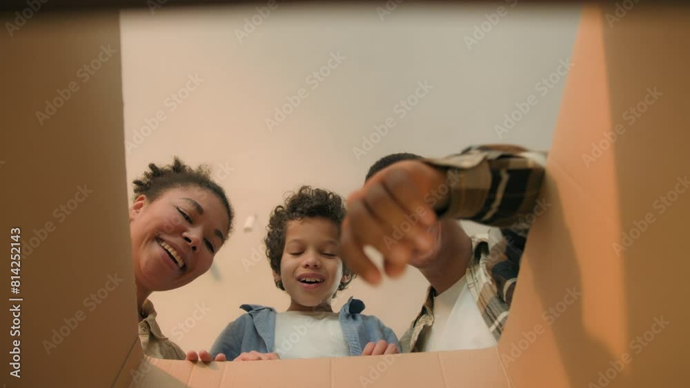 Point of view POV open box African american family parents son unpacking cardboard parcel happy funny little boy child kid surprise teddy bear toy birthday present moving day online shopping delivery