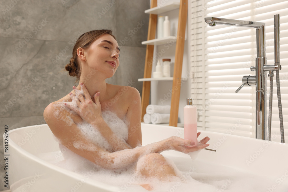 © New Africa - Woman taking bath with shower gel in bathroom © New Africa - Woman taking bath with shower gel in bathroom