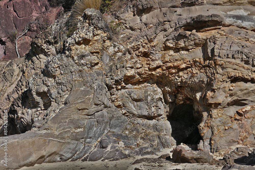 A cave is formed on the rocky foreshore by tidal movement -Pambula New South Wales Australia. A cave is formed on the rocky foreshore by tidal movement -Pambula New South Wales Australia.