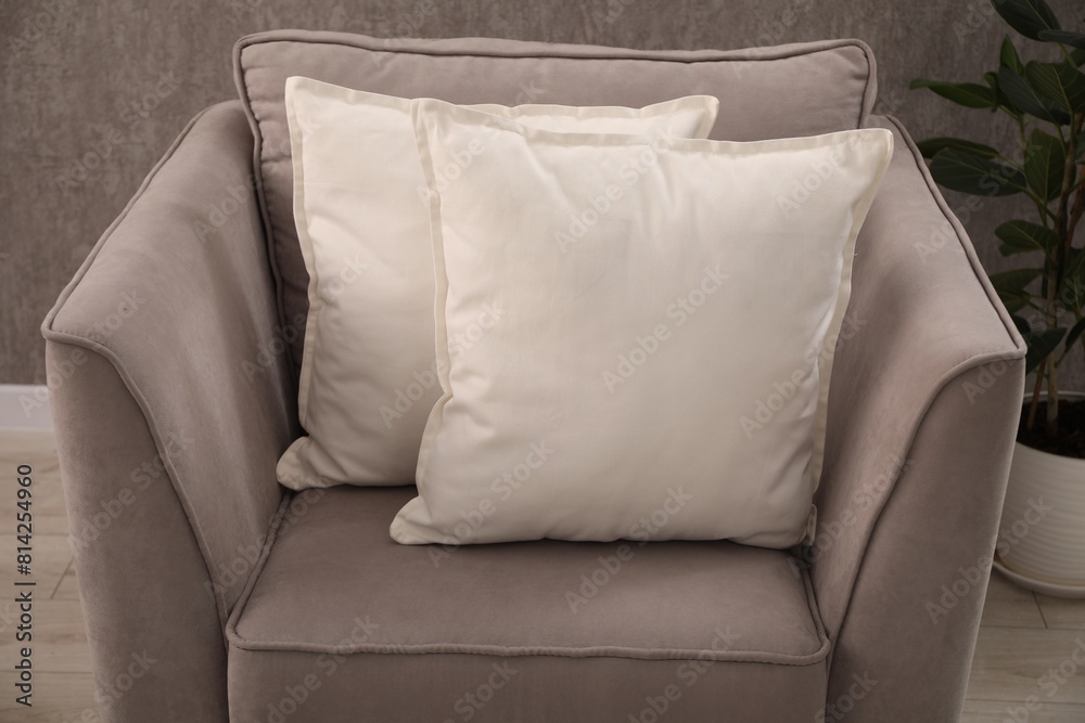 Soft pillows on grey armchair in room Soft pillows on grey armchair in room