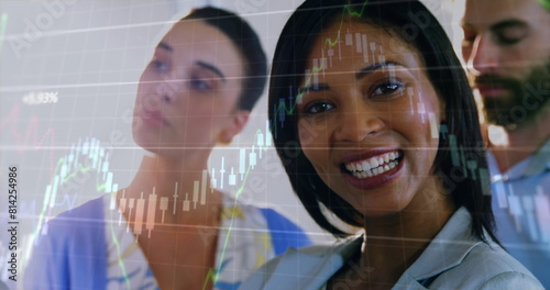 Image of graphs moving over biracial smiling businesswoman with coworkers in office