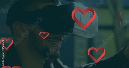 Biracial young man wearing virtual reality headset, smiling