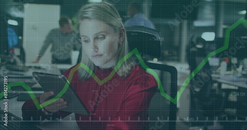 Image of financial data processing with green line over caucasian businesswoman in office