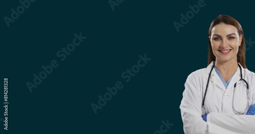 Image of smiling female caucasian doctor standing arms crossed against black background