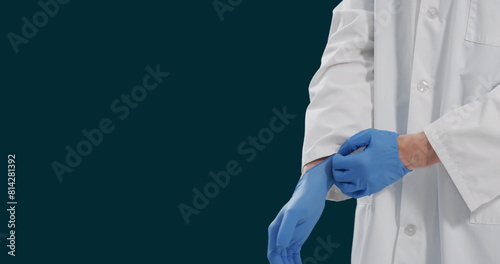 Image of midsection of caucasian male doctor wearing gloves against black background