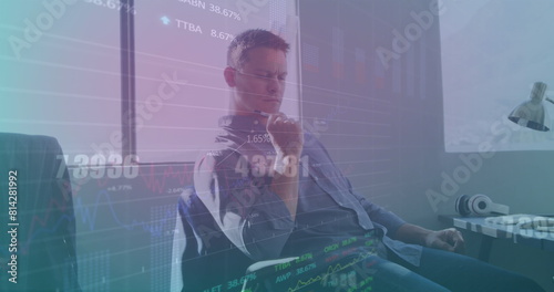 Image of graphs, changing numbers, trading board, thoughtful caucasian man in office