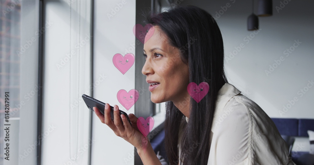 Fototapeta premium Middle-aged biracial professional holding smartphone, looking out window