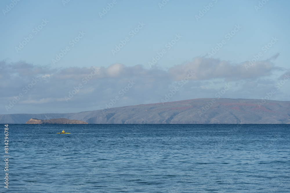 Peaceful recreation, person kayaking in the calm blue waters of the Pacific Ocean off Kamaole Beach Park II, Maui, Hawaii
