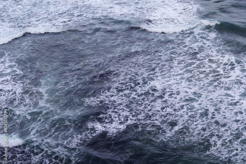 Turbulent ocean water with waves and sea foam abstract background