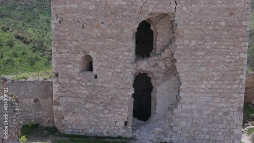 reverse flight with a close-up of a break in the tower where we see a window and stairs and discovering the magnificent location and its wild surroundings Oreja castle 9th century Ontigola Spain photo