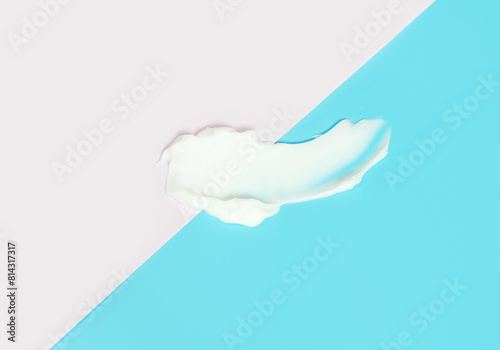 Smear of moisturizing cream on pink and blue background close-up.