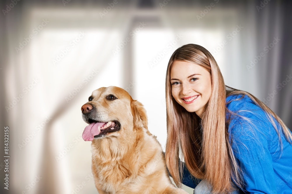 a girl holds cute domestic dog in room background