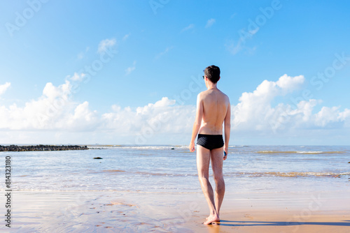 Quadro su tela Man wearing swimwear standing on the sand of a beach