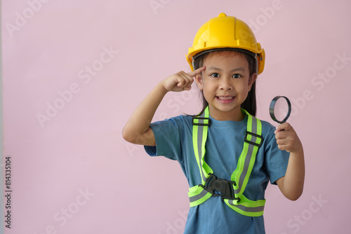 A little girl in a construction helmet and repair equipment Improving the premises About redevelopment, perspective ideas, planning, house design, architects, engineers, future careers. photo
