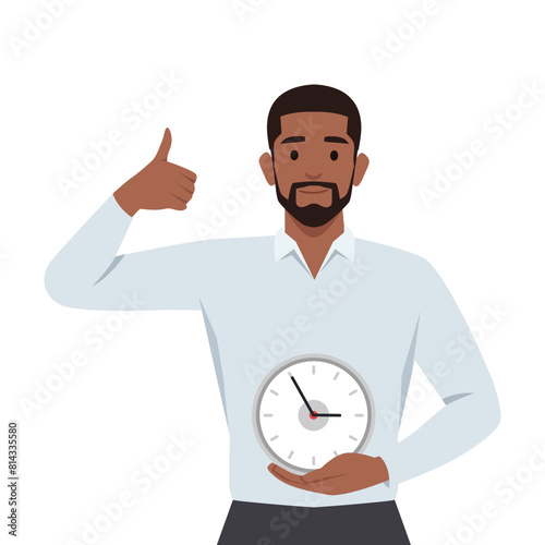 Smiling man in uniform holding clock in hands showing thumb up.