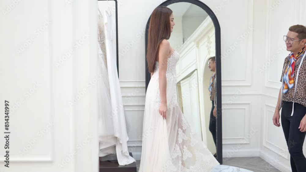Confidence Asian LGBTQ guy bridal shop owner helping woman bride choosing and trying on white wedding dress at wedding studio. Small business entrepreneur wedding planner and marriage ceremony concept Confidence Asian LGBTQ guy bridal shop owner helping woman bride choosing and trying on white wedding dress at wedding studio. Small business entrepreneur wedding planner and marriage ceremony concept