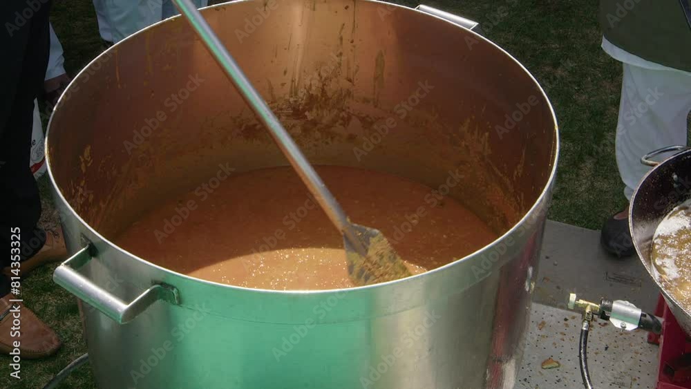 Lentil dhal in huge outdoor vat is stirred with paddle, Nagar Kirtan Lentil dhal in huge outdoor vat is stirred with paddle, Nagar Kirtan