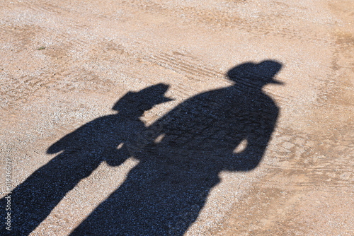 Shadows of adult and child cow boys photo