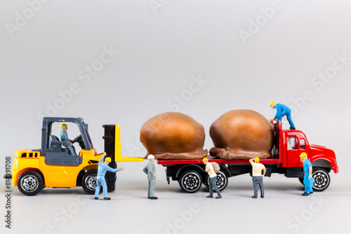 Miniature worker team moving chocolate ball from truck on a gray background, world chocolate day concept