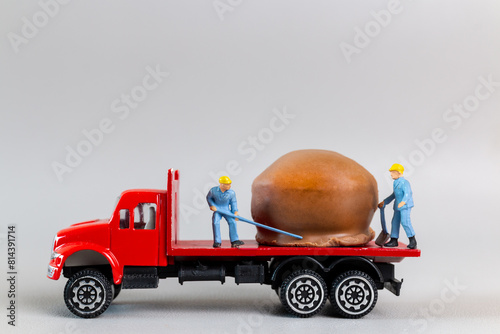 Miniature worker team moving chocolate ball from truck on a gray background, world chocolate day concept