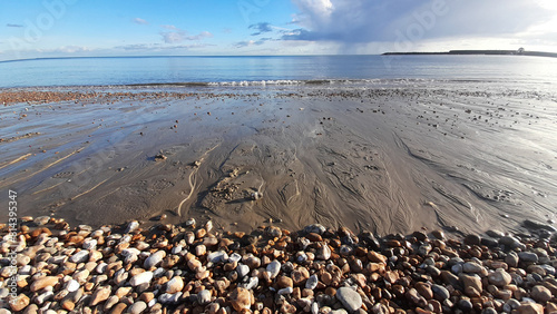 Εκτύπωση καμβά Small waves lapping the shore over sand and pebbles on a sunny summers day at Ly