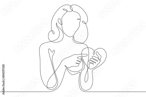 One continuous line.Beautiful woman holding a heart in her hands.Valentine's Day. Girl with a heart symbol of love. Continuous line drawing.Lineart isolated white background.