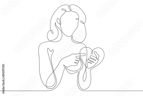 One continuous line.Beautiful woman holding a heart in her hands.Valentine's Day. Girl with a heart symbol of love. Continuous line drawing.Lineart isolated white background.