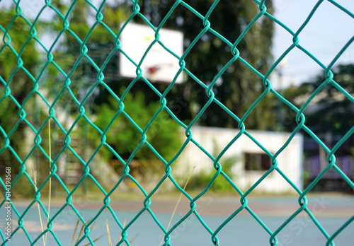 Blurred of basketball hoop background with steel mesh fence foreground, Sport theme