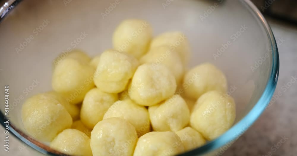 Spoon stirring hot dumplings in glass bowl with steam, set against granite background. Culinary scene captures food preparation process with vibrant colors and textures. Spoon stirring hot dumplings in glass bowl with steam, set against granite background. Culinary scene captures food preparation process with vibrant colors and textures.