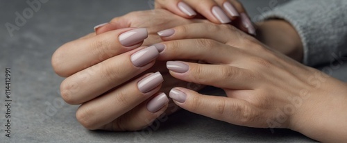 Closeup to woman hands with elegant nertral colors nails