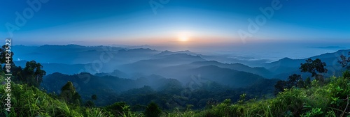 Mountain view morning panorama 180 degree of many hills and green forest cover with soft mist with blue sky background, sunrise at Solder Camp View Point, Doi Ang Khang, Chiang Mai, northern Thailand photo