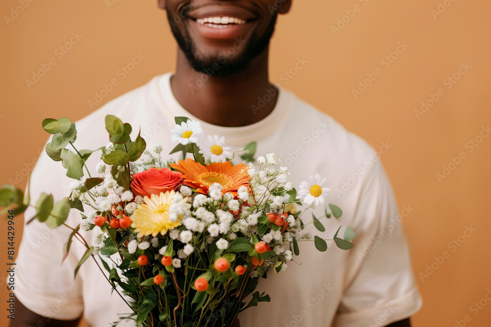 African American man holding a beautiful bouquet of flowers, beige background African American man holding a beautiful bouquet of flowers, beige background