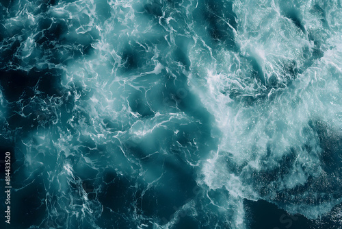 Dynamic photo of the sea's turbulent textures in shades of teal and dark blue, showcasing the chaotic energy of ocean waves